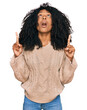 © Krakenimages.com - Young african american girl wearing casual clothes amazed and surprised looking up and pointing with fingers and raised arms.