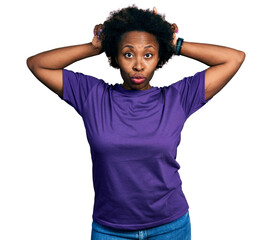 Canvas Print - African american woman with afro hair wearing casual purple t shirt doing funny gesture with finger over head as bull horns