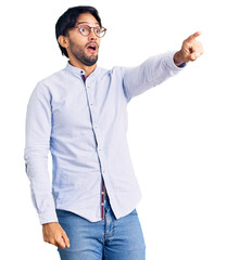 Poster - Handsome hispanic man wearing business shirt and glasses pointing with finger surprised ahead, open mouth amazed expression, something on the front