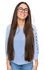 Wall Mural - Young hispanic girl wearing casual clothes and glasses looking positive and happy standing and smiling with a confident smile showing teeth