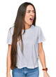© Krakenimages.com - Young hispanic girl wearing casual white t shirt angry and mad screaming frustrated and furious, shouting with anger. rage and aggressive concept.