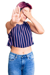 Poster - Young beautiful woman with pink hair wearing casual clothes covering eyes with hands and doing stop gesture with sad and fear expression. embarrassed and negative concept.