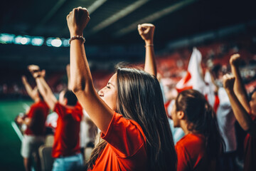 Football fan crowd cheering and supporting favourite soccer team on the stadium. World cup event. Woman at soccer match. Final win.