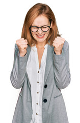 Poster - Young caucasian woman wearing business style and glasses excited for success with arms raised and eyes closed celebrating victory smiling. winner concept.