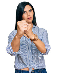 Young caucasian woman wearing casual clothes punching fist to fight, aggressive and angry attack, threat and violence