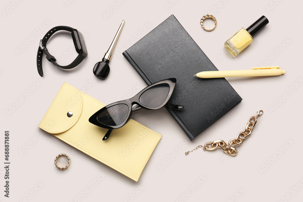 Composition with stylish sunglasses, modern smartwatch, notebook and female accessories on grey background