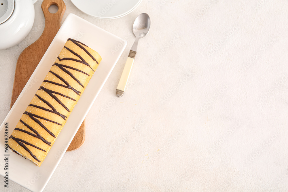 Plate with sweet sponge cake roll on white background