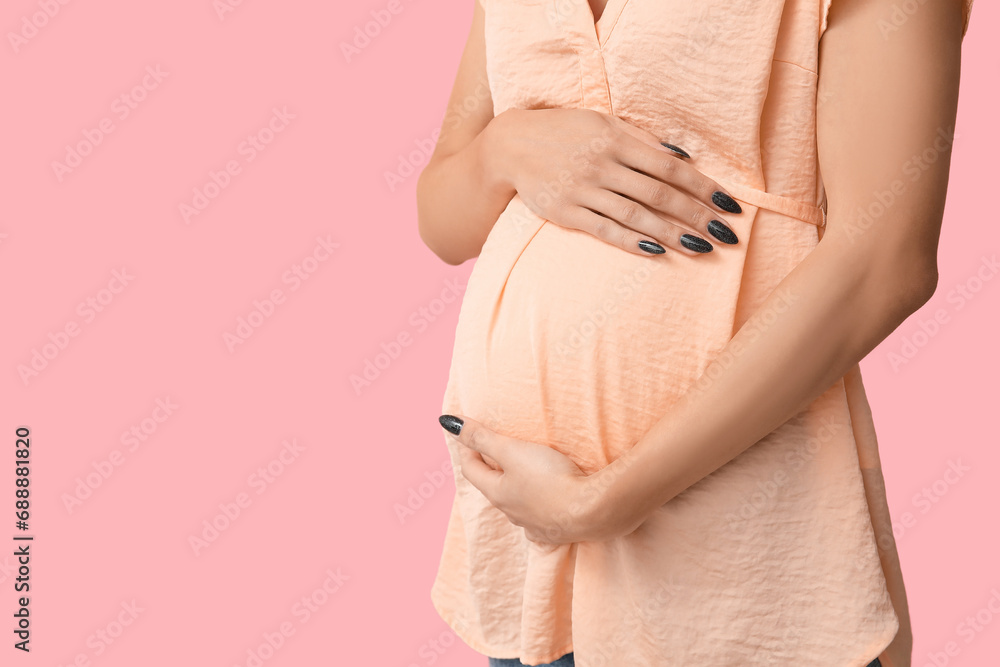 Pregnant woman on pink background, closeup