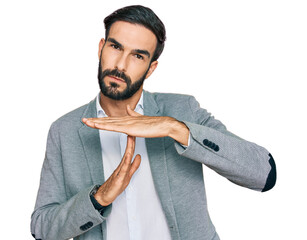 Canvas Print - Young hispanic man wearing business clothes doing time out gesture with hands, frustrated and serious face