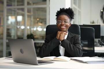 Canvas Print - Happy woman working at table in office. Lawyer, businesswoman, accountant or manager