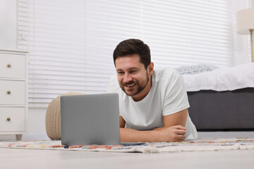 Canvas Print - Happy man having video chat via laptop at home