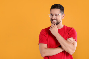 Poster - Portrait of happy man in stylish glasses on yellow background. Space for text