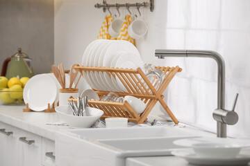 Poster - Sink and drying rack with clean dishes and cutlery on countertop in kitchen