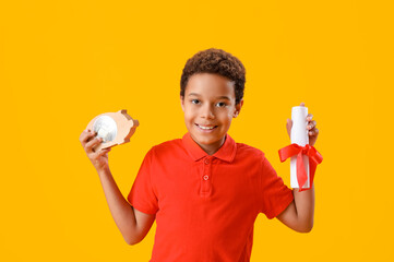 Sticker - Little African-American boy with piggy bank and diploma on yellow background