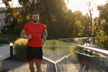 Canvas Print - Happy man running outdoors on sunny day. Space for text