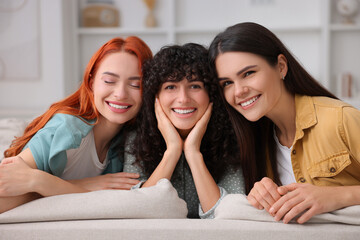 Canvas Print - Portrait of happy young friends on sofa at home