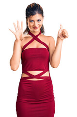 Sticker - Young beautiful woman wearing casual clothes showing and pointing up with fingers number six while smiling confident and happy.