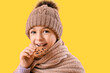© Pixel-Shot - Cute little girl eating cookie on yellow background