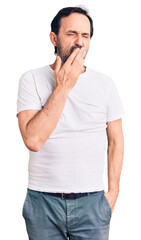 Wall Mural - Middle age handsome man wearing casual t-shirt bored yawning tired covering mouth with hand. restless and sleepiness.