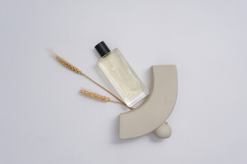 Canvas Print - Bottles of cosmetic essential oil on white background with gray prop and wheat. Minimal scene for advertising perfume product. Top view, mockup bottle unlabeled for design