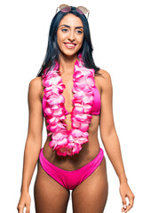 Wall Mural - Beautiful hispanic woman wearing bikini and hawaiian lei looking away to side with smile on face, natural expression. laughing confident.