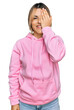 © Krakenimages.com - Young caucasian woman wearing casual sweatshirt covering one eye with hand, confident smile on face and surprise emotion.