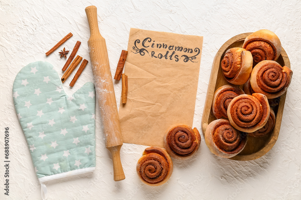 Composition with tasty cinnamon rolls on white background