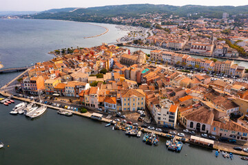Wall Mural - Picturesque aerial view of coastal town of Martigues divided by canals overlooking marina and residential buildings along waterfronts in warm autumn day, France