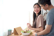 © DG PhotoStock - Happy cheerful Asian young couple preparing a vegetable salad in kitchen together in weekend.
