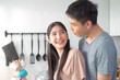 © DG PhotoStock - Happy cheerful Asian young couple preparing a vegetable salad in kitchen together in weekend.