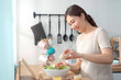 © DG PhotoStock - woman enjoy preparing salad in a wooden bowl.