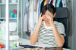 © DG PhotoStock - Stressful Asian young woman fasion designer taking a rest after working for many hours.