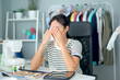© DG PhotoStock - Stressful Asian young woman fasion designer taking a rest after working for many hours.