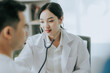 © Witoon - Female doctor using stethoscope to diagnose heart with male patient in examination room at hospital, physical examination, medicine and healthcare Heart disease and medical health concept