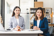 © NanSan - Two middle aged and young Asian lawyer in a formal suit consoles a client during a legal consultation, with a gavel and documents on the table.
