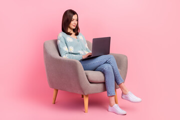 Poster - Full length body photo of concentrated young assistant woman work remote sitting armchair with laptop isolated on pink color background