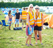 © Duncan M/peopleimages.com - Portrait, sunglasses and event staff at festival for music, party and carnival outdoor in summer. Happy women, girls camping and security team in headset, safety vest or celebration concert in nature