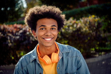 Canvas Print - Portrait of good mood satisfied guy with chevelure wear denim shirt headphones toothy smiling at camera at sunny weather in park outdoors