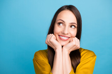 Poster - Photo of good mood dreamy woman dressed yellow shirt arms cheeks looking empty space isolated blue color background