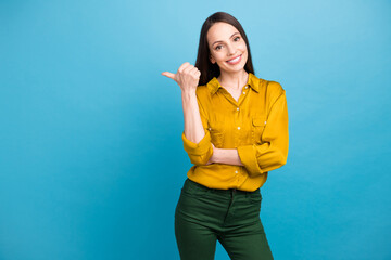 Wall Mural - Photo of cheerful good mood woman dressed yellow shirt showing thumb empty space isolated blue color background