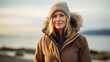 Scandinavian woman walks along the shore of the Baltic Sea in cold weather. Active life after 45 years. Healthy lifestyle