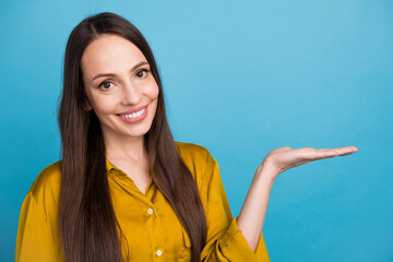 Canvas Print - Photo of toothy shiny woman dressed yellow shirt showing arm empty space isolated blue color background