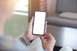 © panitan - cell phone blank white screen mockup.hand holding texting using mobile on desk at office.background empty space for advertise.work people contact marketing business,technology