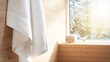 © Bartomiej - Drewniana minimalistyczna sauna z ręcznikiem wiszącym na ścianie