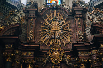 A golden flaming, radiant delta with the all-seeing eye of the Christian God or the great architect of the Masons, surrounded by seraphim. Relief and sculptures. Jesuit Church in Lviv, Ukraine.