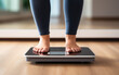 Closeup woman legs standing on an electronic weight scales