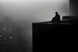 A silhouette of solitary depression man figure sitting on the roof of a tall building, with an empty gaze into thick fog
