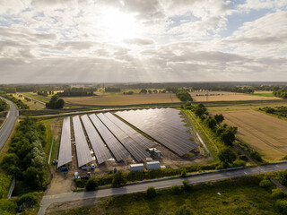 Wall Mural - Drone Shot of solar panels at a sunny day between fields, river and a street.