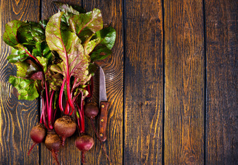 Wall Mural - fresh beets on cutting board, set on wooden table viewed from above