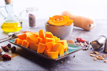 Wall Mural - Diced pumpkin pieces in a bowl, with spices and olive oil at home